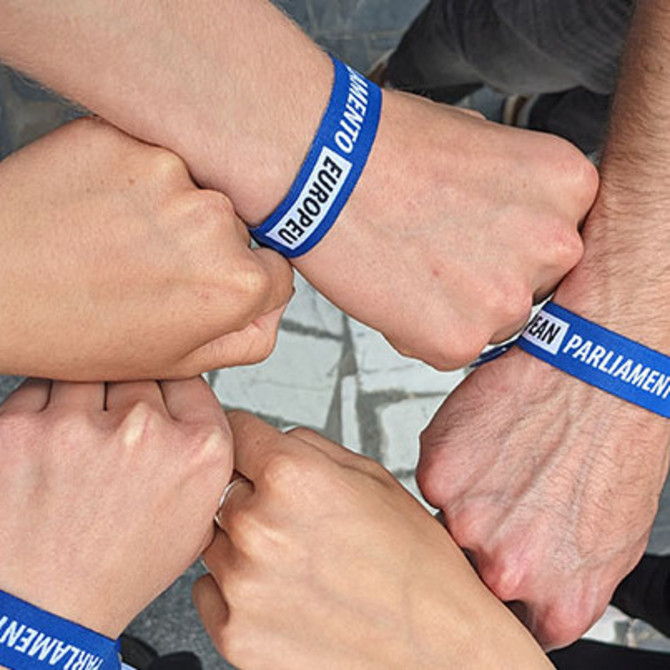 5 Fäuste mit einem Armband vom Europäischen Parlament bilden einen Kreis